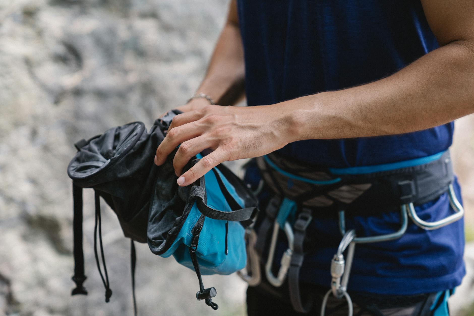 Trening siły pod podciągnięcia i przewieszenia: plan dla turystów w Tatrach Mężczyzna na zewnątrz przygotowuje sprzęt wspinaczkowy przed treningiem