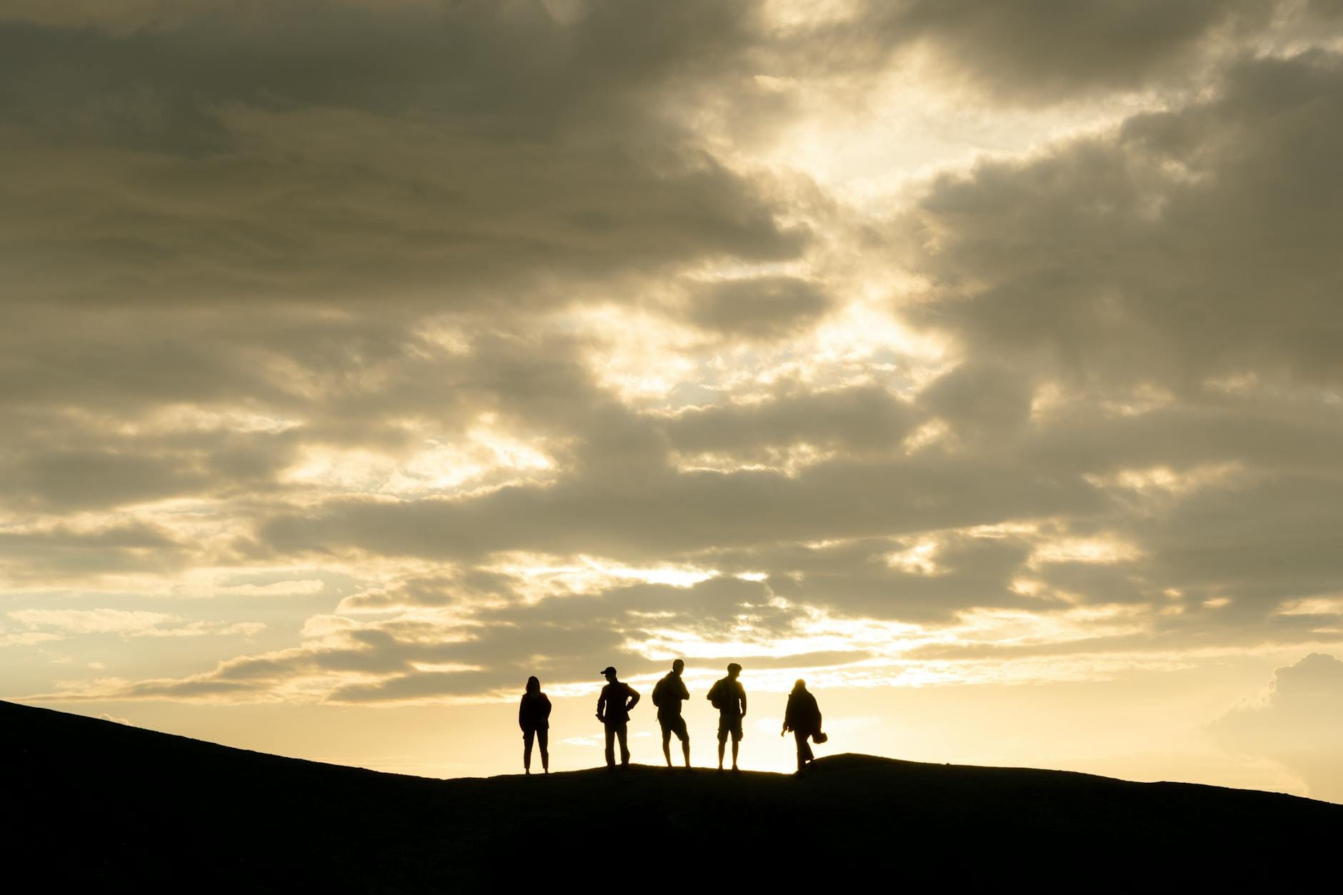 Sylwetki grupy turystów na grani w Tatrach o zachodzie słońca