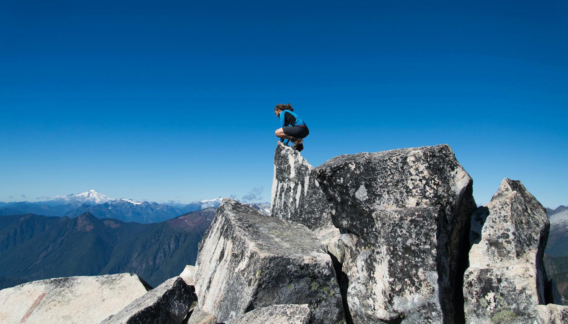 Wspinacz w czerwonej kurtce na szczycie wysokiej tatrzańskiej góry