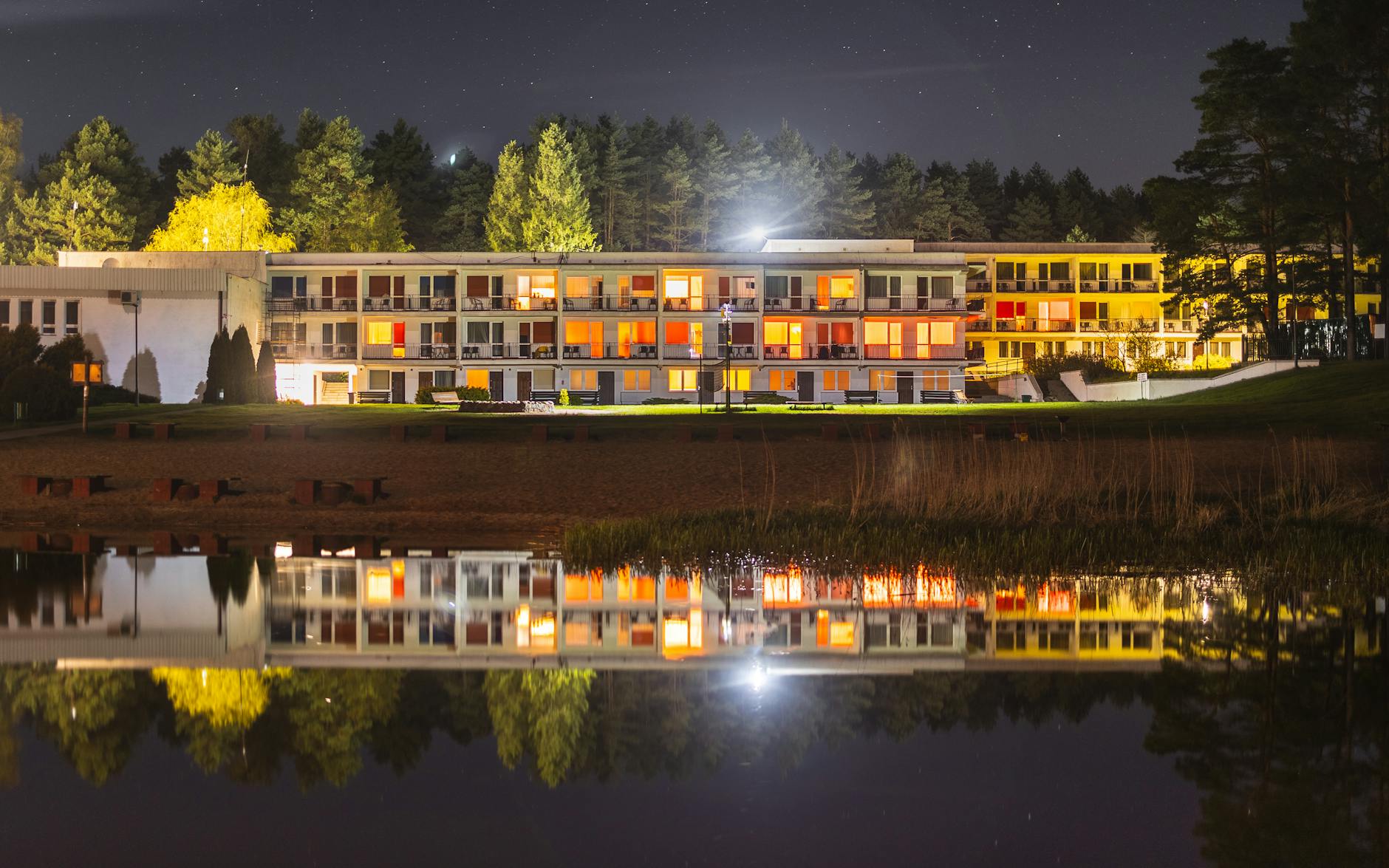 Nocny widok górskiego kurortu nad jeziorem w świetle latarni
