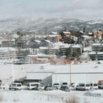Zimowa panorama górskiego miasteczka z ośnieżonymi szczytami w tle