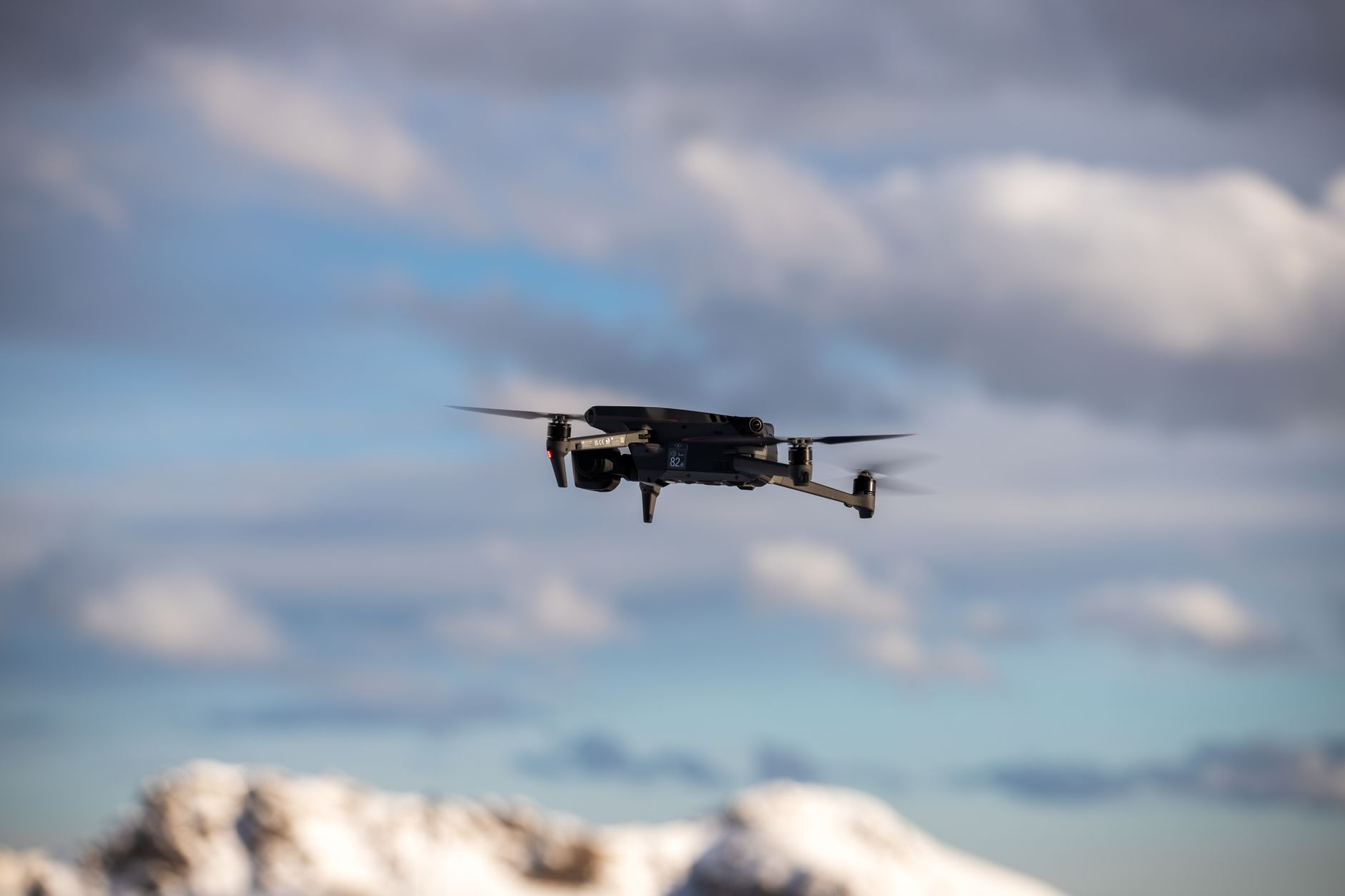 Dron lecący nad ośnieżonymi tatrzańskimi szczytami pod burzowymi chmurami