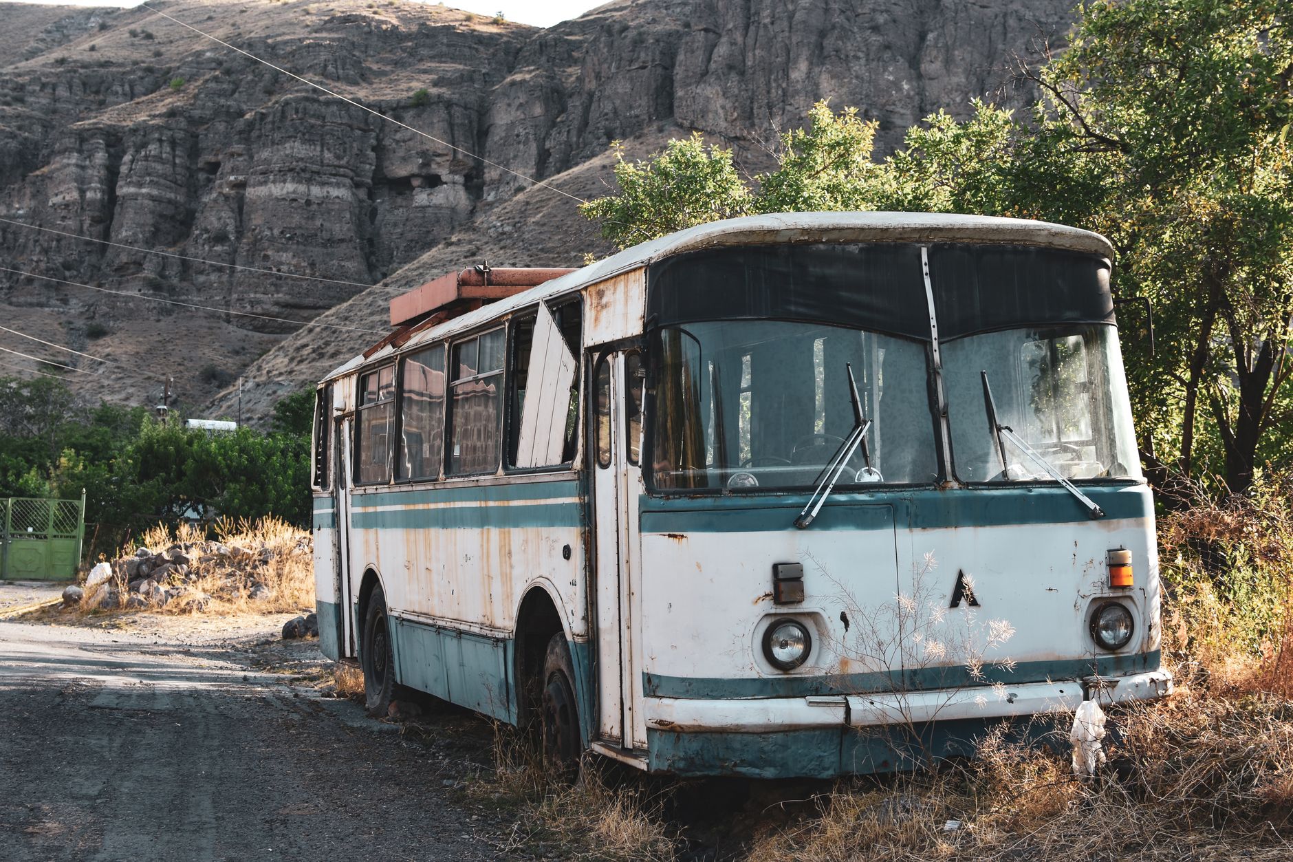Stary autobus stojący samotnie w górskim krajobrazie o zachodzie słońca