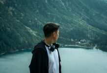 Schronisko Morskie Oko: jak dotrzeć po raz pierwszy, czas przejścia asfaltem i alternatywy Mężczyzna podziwia Morskie Oko otoczone las